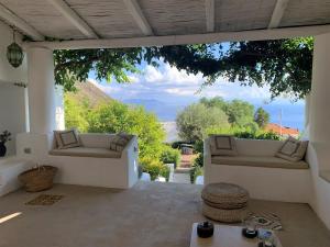 a patio with couches and a view of the ocean at Villa Il Melograno in Leni