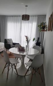 ein Wohnzimmer mit einem weißen Tisch und Stühlen in der Unterkunft Hermoso Departamento en Temperley in Temperley