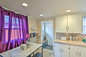 a kitchen with purple curtains and a table and a counter at Lovely Tacoma Cottage with Fire Pit, Near Dtwn! in Tacoma