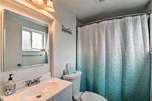 un bagno con lavandino, WC e specchio di Lovely Tacoma Cottage with Fire Pit, Near Dtwn! a Tacoma Altre 18 foto
