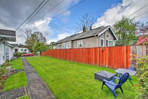 a yard with a fence and two chairs and a table at Lovely Tacoma Cottage with Fire Pit, Near Dtwn! in Tacoma