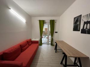 a living room with a red couch and a table at Il Guasco Rooms in Ancona