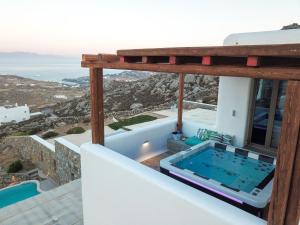 uma casa com uma piscina de mergulho numa varanda em Amallini Suites Mykonos em Praia Super Paradise
