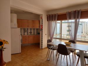 uma cozinha e sala de jantar com uma mesa e uma janela em Alltravel Safira Apartment em Portimão