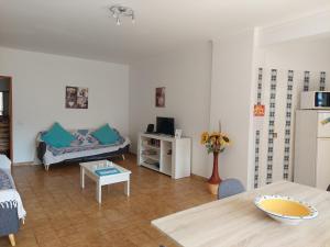 uma sala de estar com um sofá e uma mesa em Alltravel Safira Apartment em Portimão
