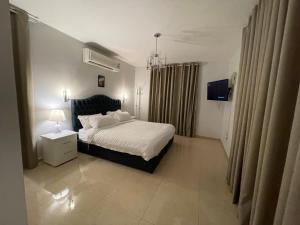 a bedroom with a bed and a chandelier at سافانا امواج Amwaj savana in Half Moon Bay