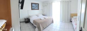 a bedroom with a bed with two towels on it at Vila Alaide Praia Hotel in Barra Velha