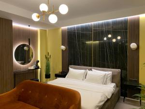 a bedroom with a bed and a chair and a mirror at Luxury Sahara Noir Mamaia Nord in Mamaia