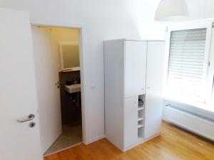 Armario blanco en una habitación con ventana en Zentrale ruhige Lage mit Parkplatz und Terrasse, en Bad Honnef am Rhein