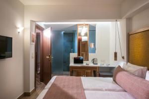 ein Schlafzimmer mit einem Bett und ein Badezimmer mit einem Waschbecken in der Unterkunft Anesis Blue Boutique Hotel in Hersonissos