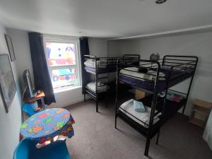 プリマスにあるPlymouth Backpackersの二段ベッド3組、窓が備わる客室です。
