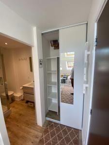 um quarto com uma porta de vidro deslizante com um espelho em studio duplex - Bord de mer em Ouistreham