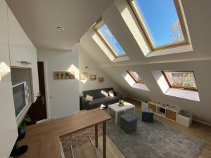 uma sala de estar no sótão com clarabóias e um sofá em studio duplex - Bord de mer em Ouistreham