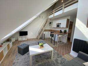 uma sala de estar com um sofá e uma mesa em studio duplex - Bord de mer em Ouistreham