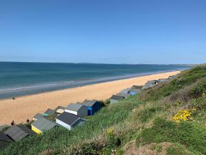 a beach with a bunch of buildings on it at Luxury Seaside Retreat Holiday Home - Shorefield Country Park in Downton +6 photos
