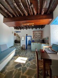 a living room with a bed and a table with a laptop at Le petit château in Ano Syros