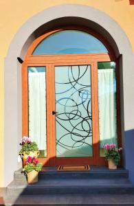 una porta di vetro con due piante in vaso sui gradini di Casa Lamberti B&B a Cava deʼ Tirreni