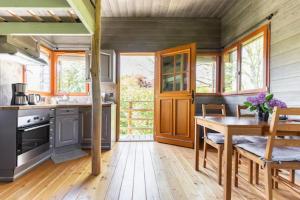 uma cozinha com pisos em madeira, uma mesa e cadeiras em Cabane perchee em Vert