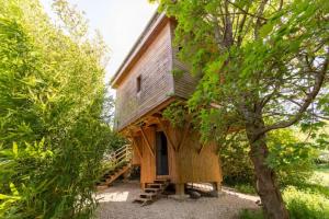 una pequeña casa de madera con una escalera que conduce a ella en Cabane perchee, en Vert