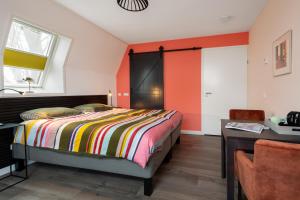 a bedroom with a bed and a table and a desk at Lowlander BnB in Heemskerk