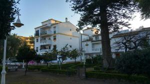 a white building with a tree in front of it at CONCHA DEL MAR PMCM in Torre del Mar
