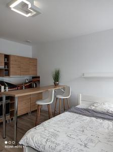 a bedroom with a bed and a desk with two chairs at Noclegi Apartamenty Sępopol in Sępopol