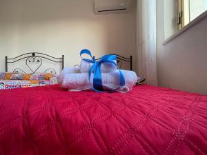 特拉帕尼的住宿－Sunset，床上的一大堆枕头,上面有蓝色的弓