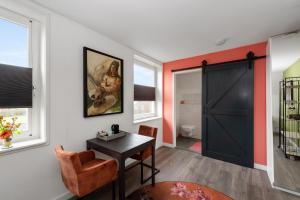 a room with a black door and a table and chairs at Lowlander BnB in Heemskerk