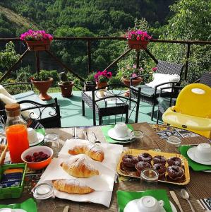 - une table avec des pâtisseries et des boissons sur la terrasse dans l'établissement B&B Il Ghiro-Country House, à Mormanno