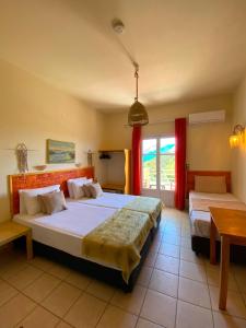 1 dormitorio grande con 2 camas y ventana en Villa Krini, en Skiathos
