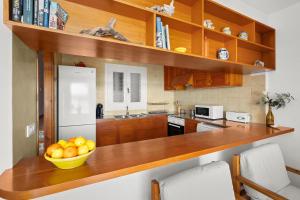 a kitchen with a bowl of fruit on a wooden counter at Tramontana Apartment 99BJ in Fornells