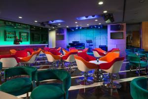 una habitación con sillas coloridas y un bar en Richmonde Hotel Ortigas, en Manila