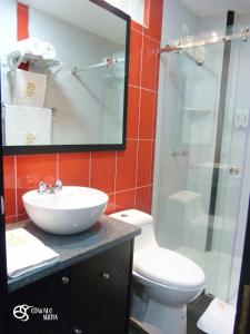a bathroom with a toilet and a sink and a shower at Otavalo Suites in Otavalo