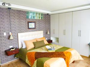 sypialnia z dużym łóżkiem i ceglaną ścianą w obiekcie Otavalo Suites w mieście Otavalo