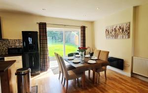 a kitchen and dining room with a table and chairs at Fairview Cottage Watford in Leavesden Green