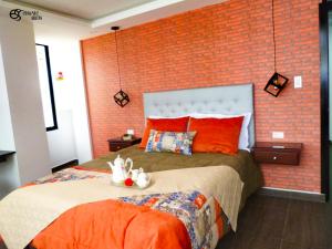 een slaapkamer met een groot bed met een bakstenen muur bij Otavalo Suites in Otavalo