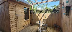 a patio with a table and chairs on a wooden deck at Le Garage in Cussy