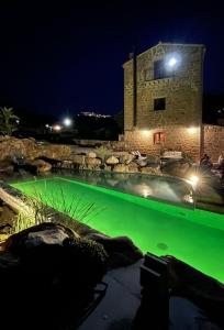 einem Pool mit grünem Wasser vor einem Gebäude in der Unterkunft Antico Borgo Buonanotte in San Mauro Castelverde