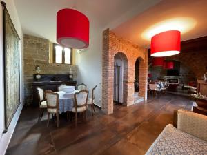 a living room with a table and chairs and red lamps at Antico Borgo Buonanotte in San Mauro Castelverde