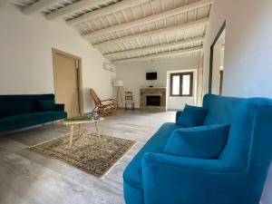 a living room with blue couches and a table at Antico Borgo Buonanotte in San Mauro Castelverde