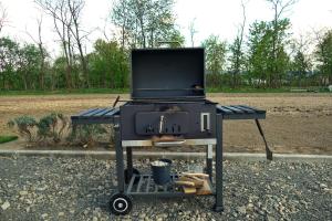 a grill sitting on a cart in a field at Agropensiunea Alex in Ocna Şugatag