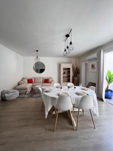 sala de estar blanca con mesa y sofá en Superbe maison de ville, en Narbona