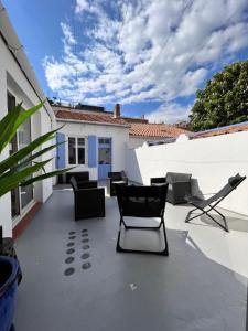 a patio with chairs and chairs on a roof at Superbe maison de ville in Narbonne