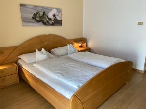 ein Bett mit einem Holzrahmen in einem Zimmer in der Unterkunft Hotel Gasthof WASTL in Appiano sulla Strada del Vino