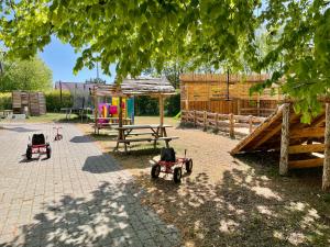 einen Spielplatz mit Spielzeugzugmaschinen auf einem Hof in der Unterkunft Hestkær Family Rooms in Grindsted