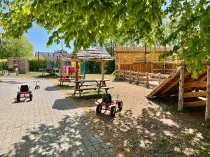 un parque infantil con tractores de juguete en un patio en Hestkær Family Rooms, en Grindsted