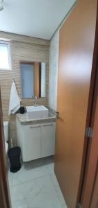a bathroom with a sink and a mirror and a door at Makambira Residence 201 in Porto De Galinhas