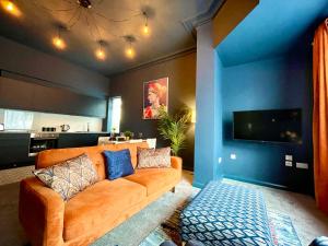 a living room with a couch and a tv at Stunning & Stylish 2 Bedroom Apartment! - 5 Minute Walk to the Best Beach! - Great Location - FREE Parking - Fast WiFi - Smart TV - Newly decorated - sleeps up to 4! Close to Bournemouth & Poole Town Centre & Sandbanks in Bournemouth