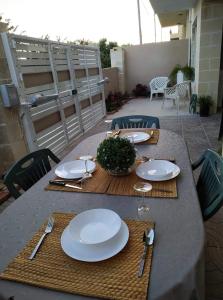 a table with plates and utensils on a patio at Jasmin at Bayview in Pembroke