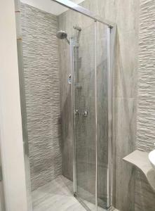 a shower with a glass door in a bathroom at Jasmin at Bayview in Pembroke